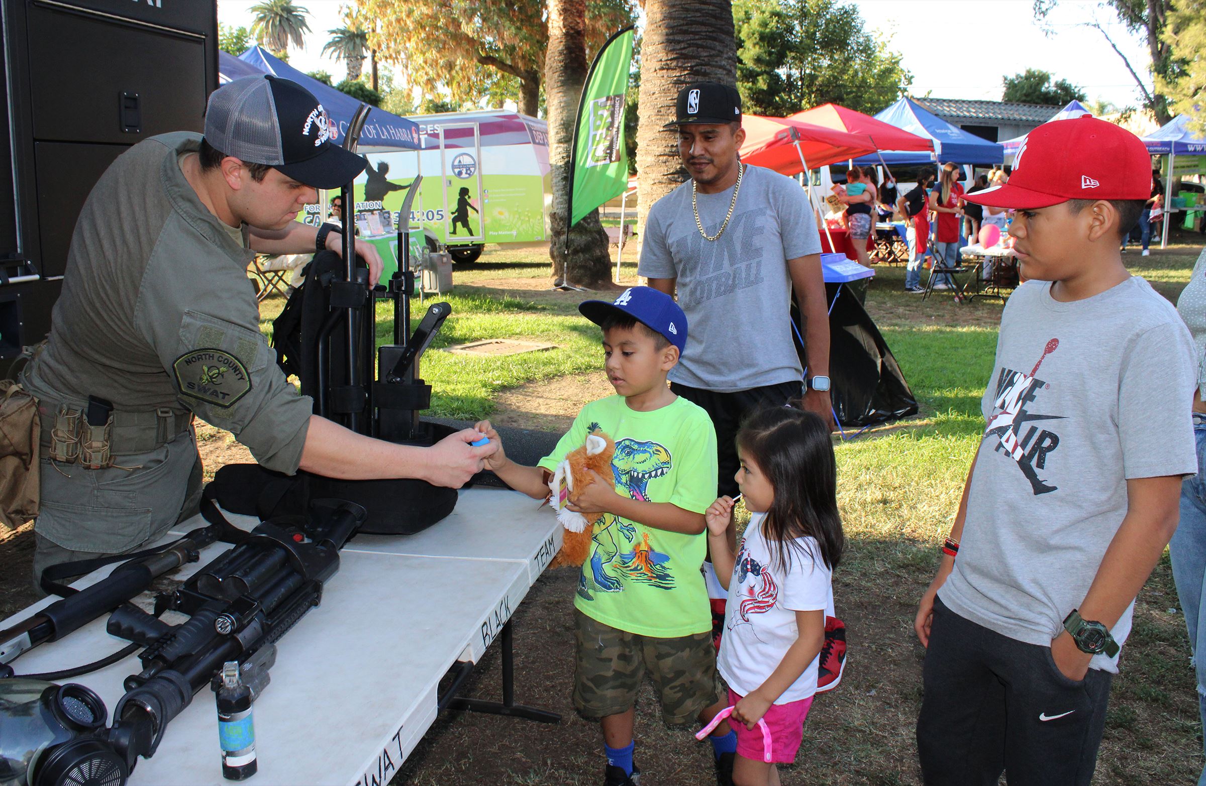 SWAT booth with officer talking to kids and father